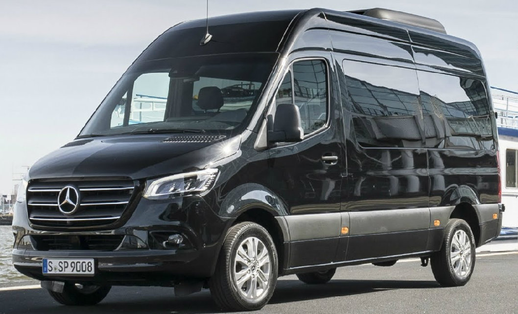A black mercedes sprinter van is parked on the side of the road.