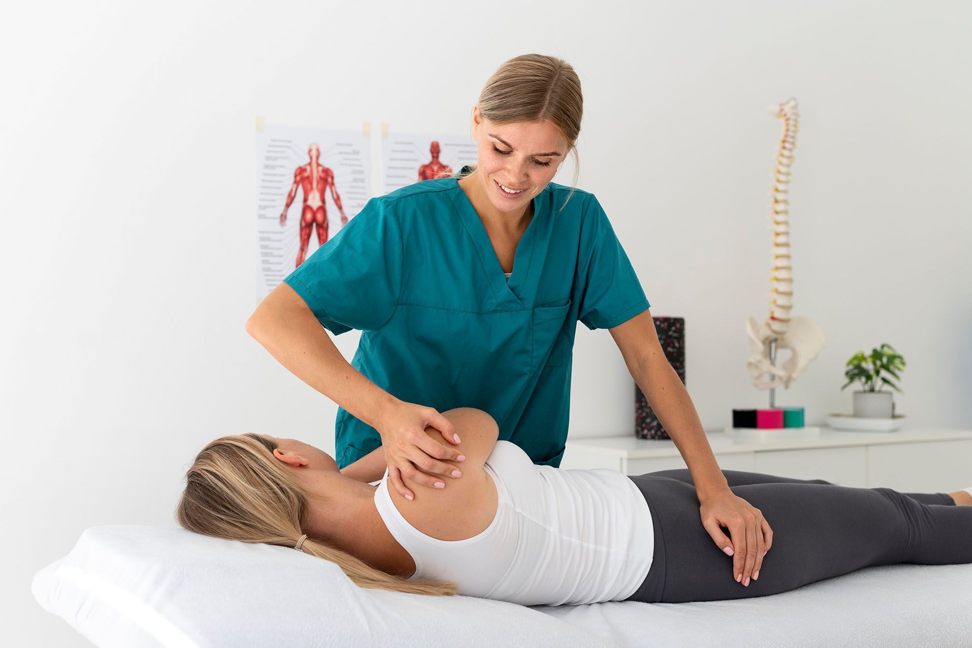 Una donna è sdraiata su un letto e riceve un massaggio da un'infermiera.