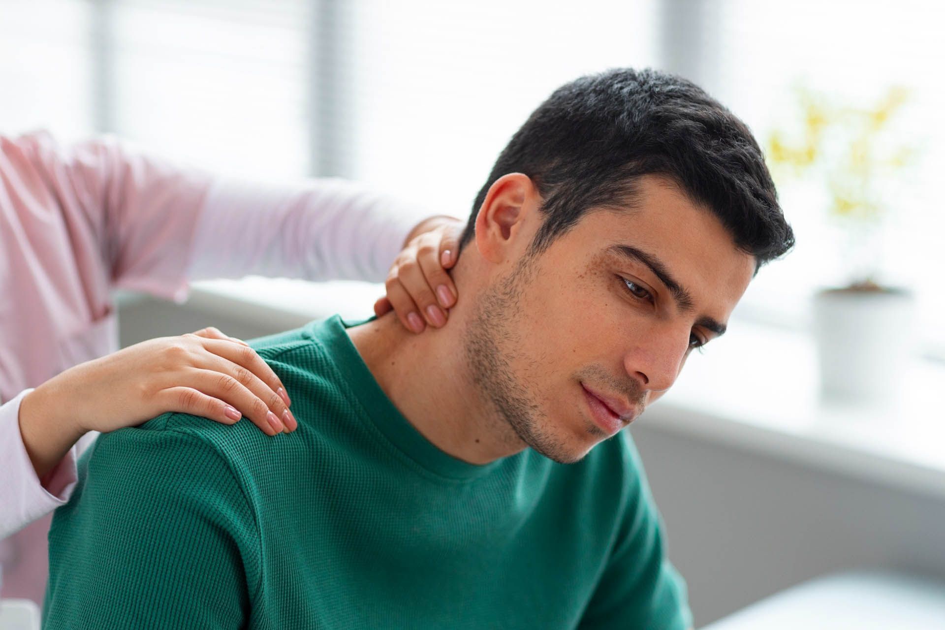 Una donna sta facendo un massaggio al collo a un uomo.
