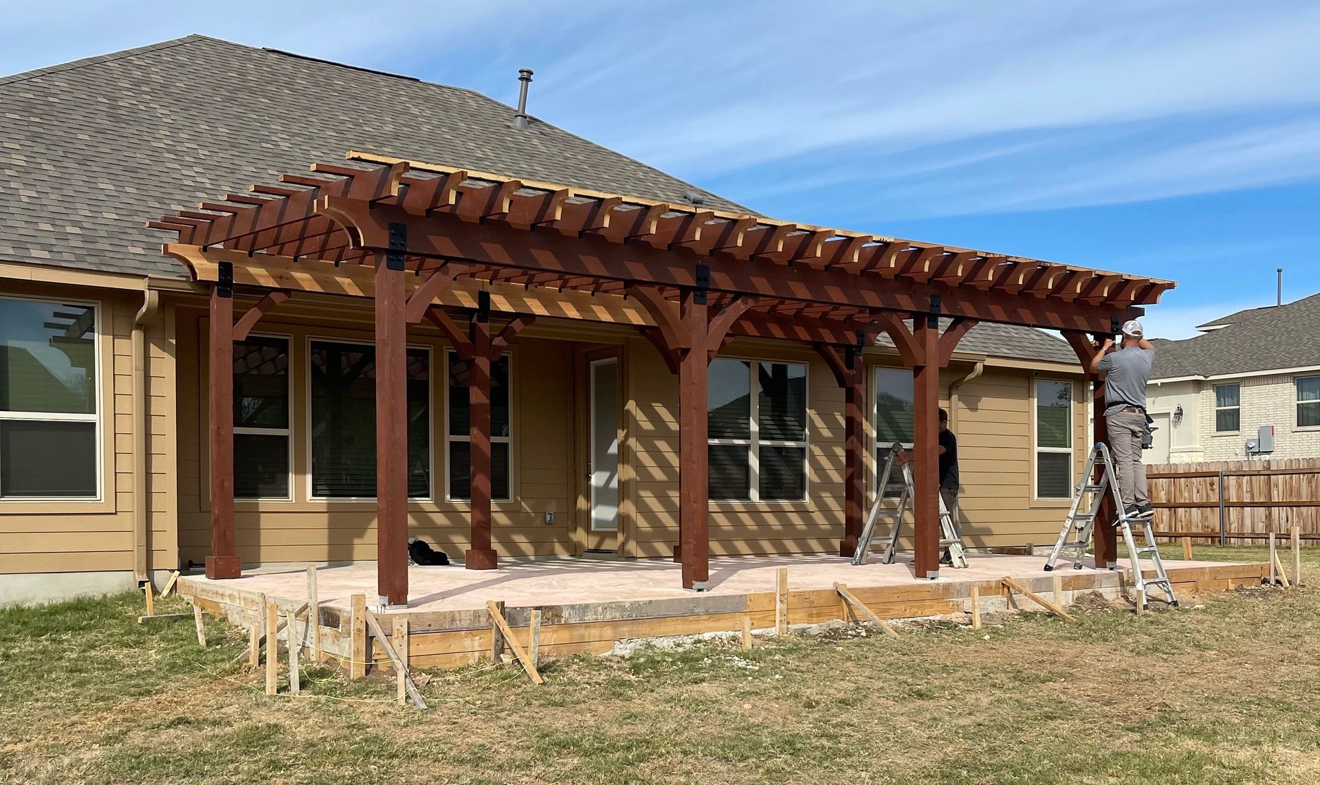 A wooden pergola is being built in front of a house.