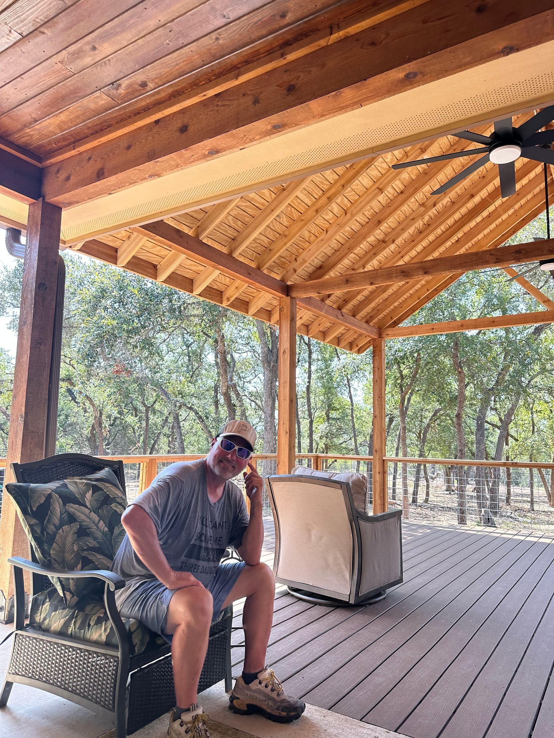 A man is sitting in a chair on a porch.