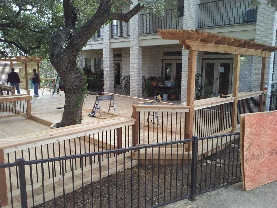 A fence surrounds a wooden deck under construction