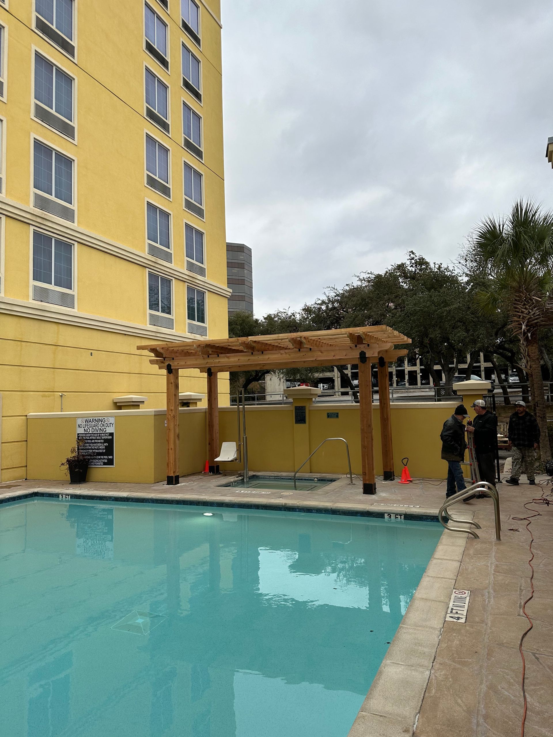 A large yellow building with a swimming pool in front of it