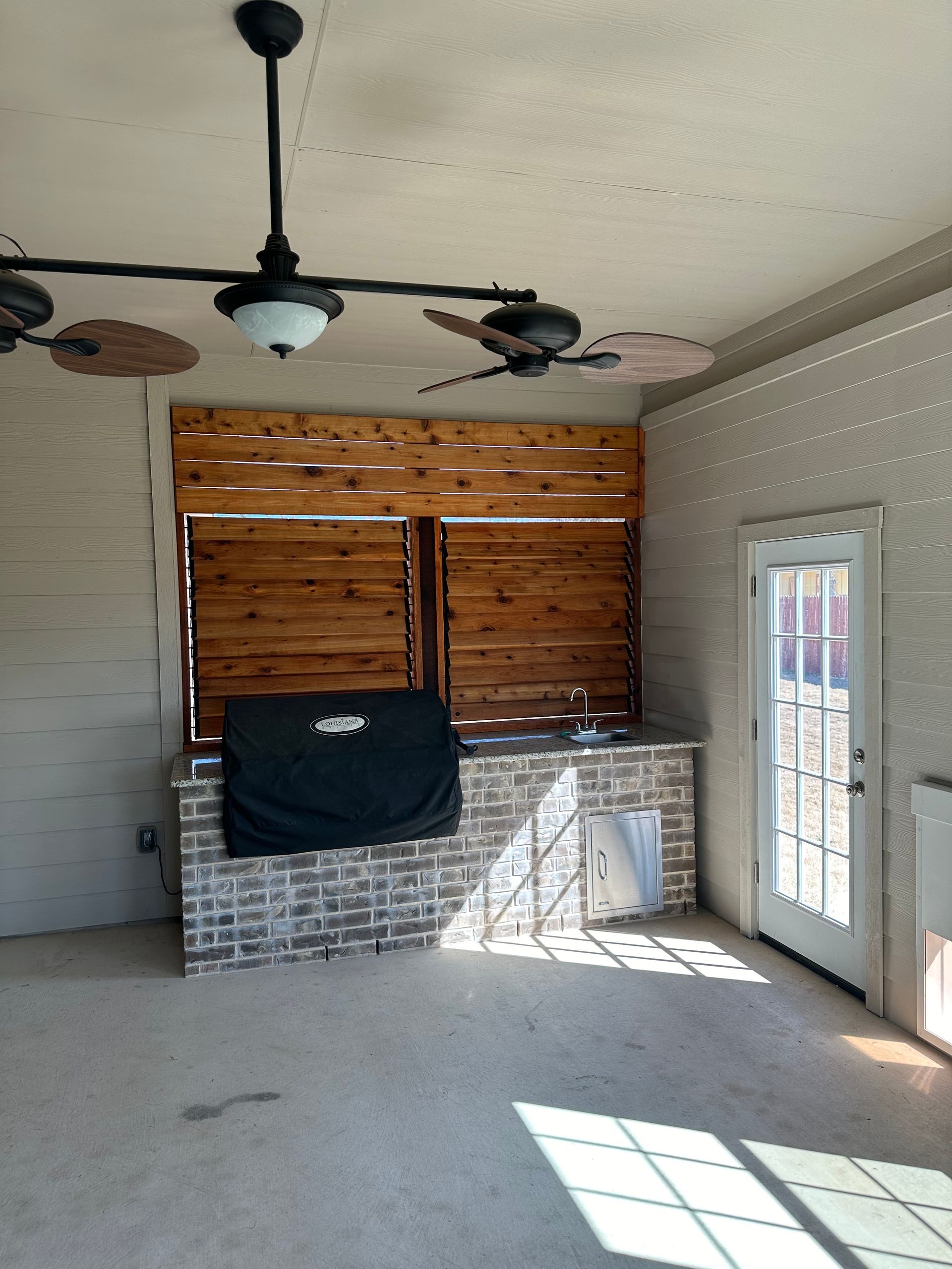 An empty room with a grill and ceiling fans