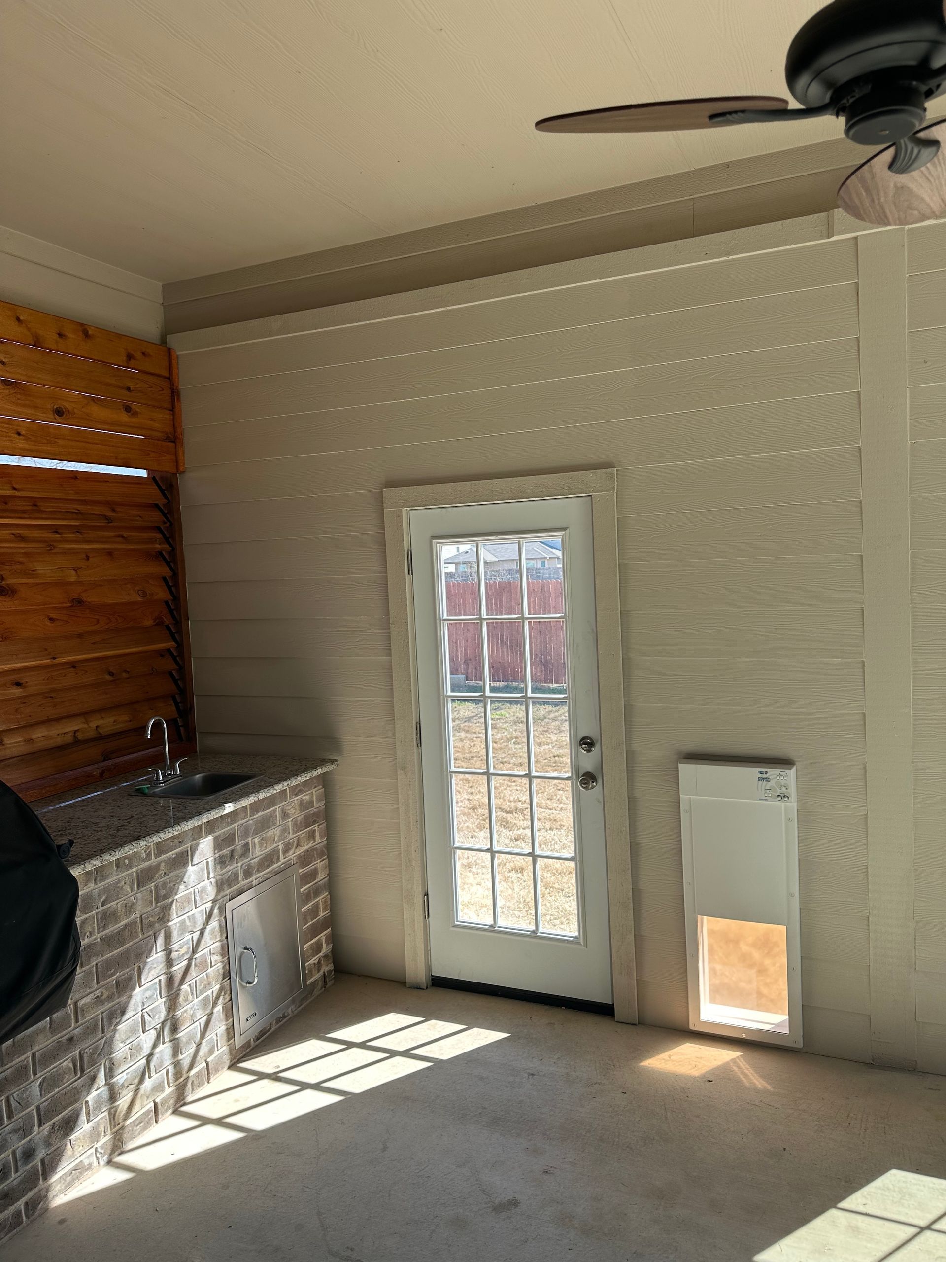 An empty room with a door and a ceiling fan