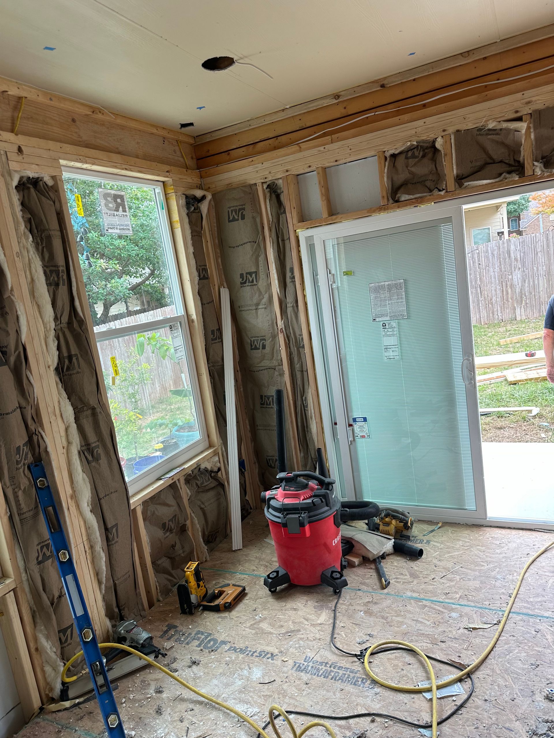 A vacuum cleaner is sitting on the floor in a room under construction.