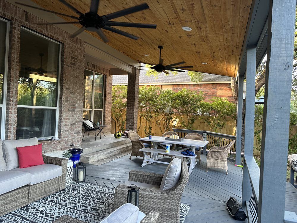 There is a ceiling fan on the porch of a house.