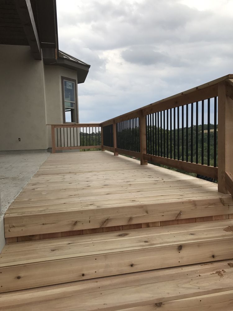 A wooden deck with stairs leading up to it and a railing.