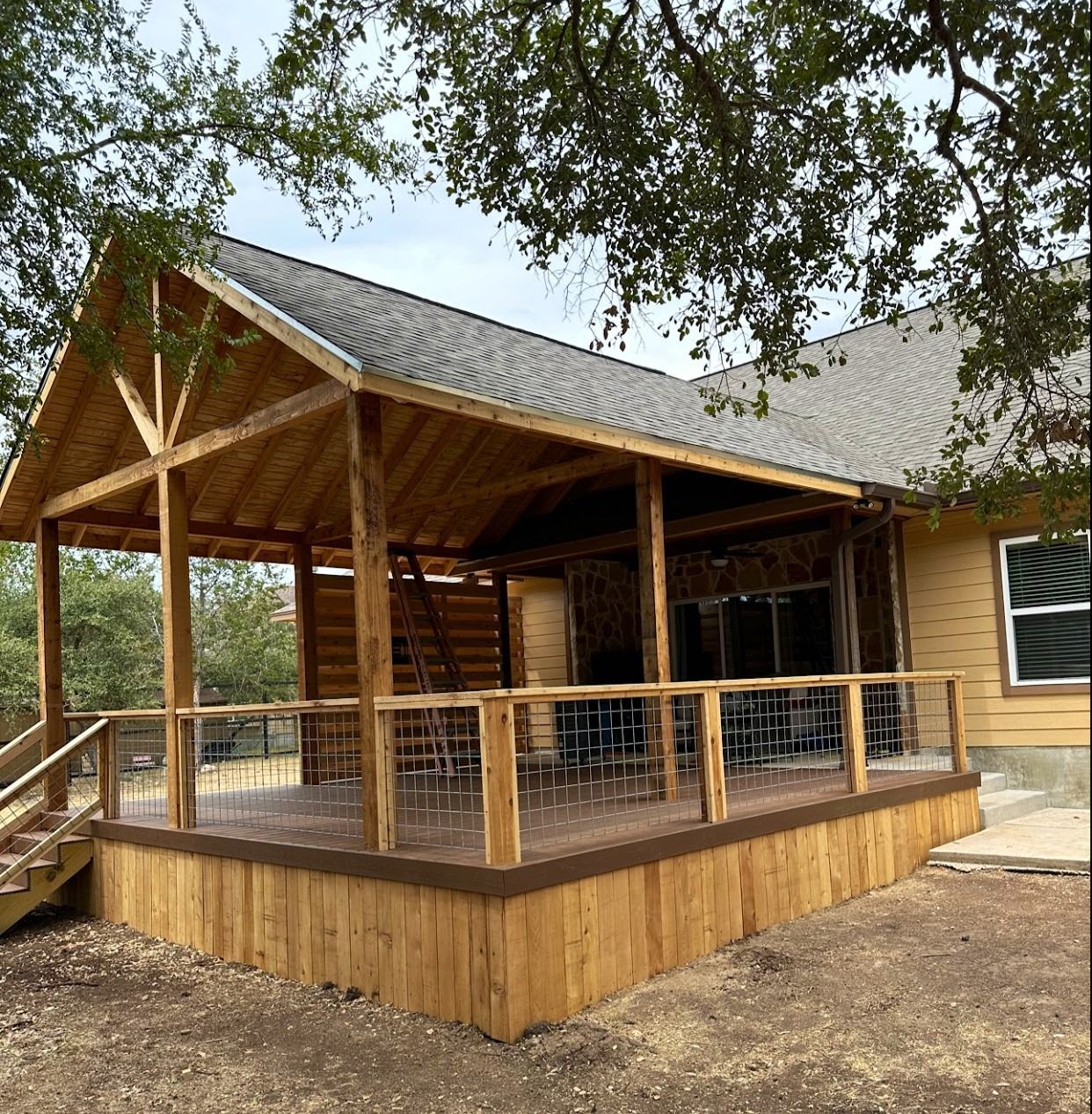 A wooden house with a large porch and a roof.