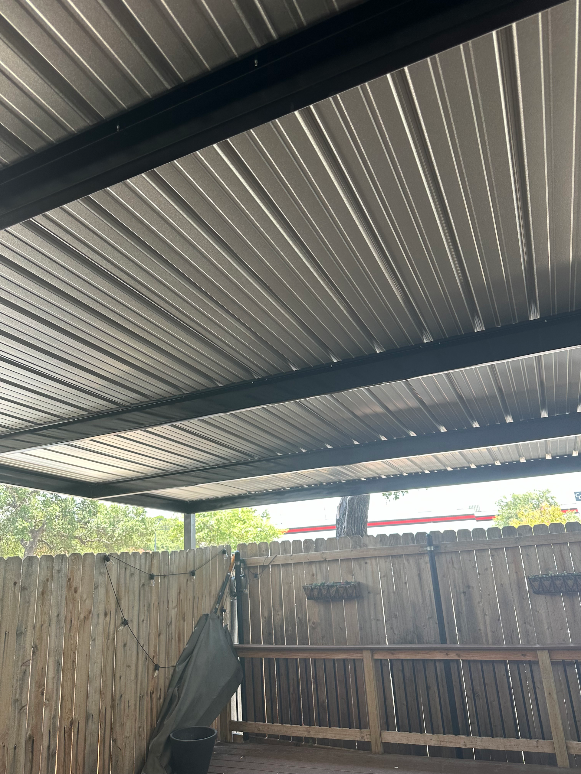 A metal roof with a wooden fence in the background