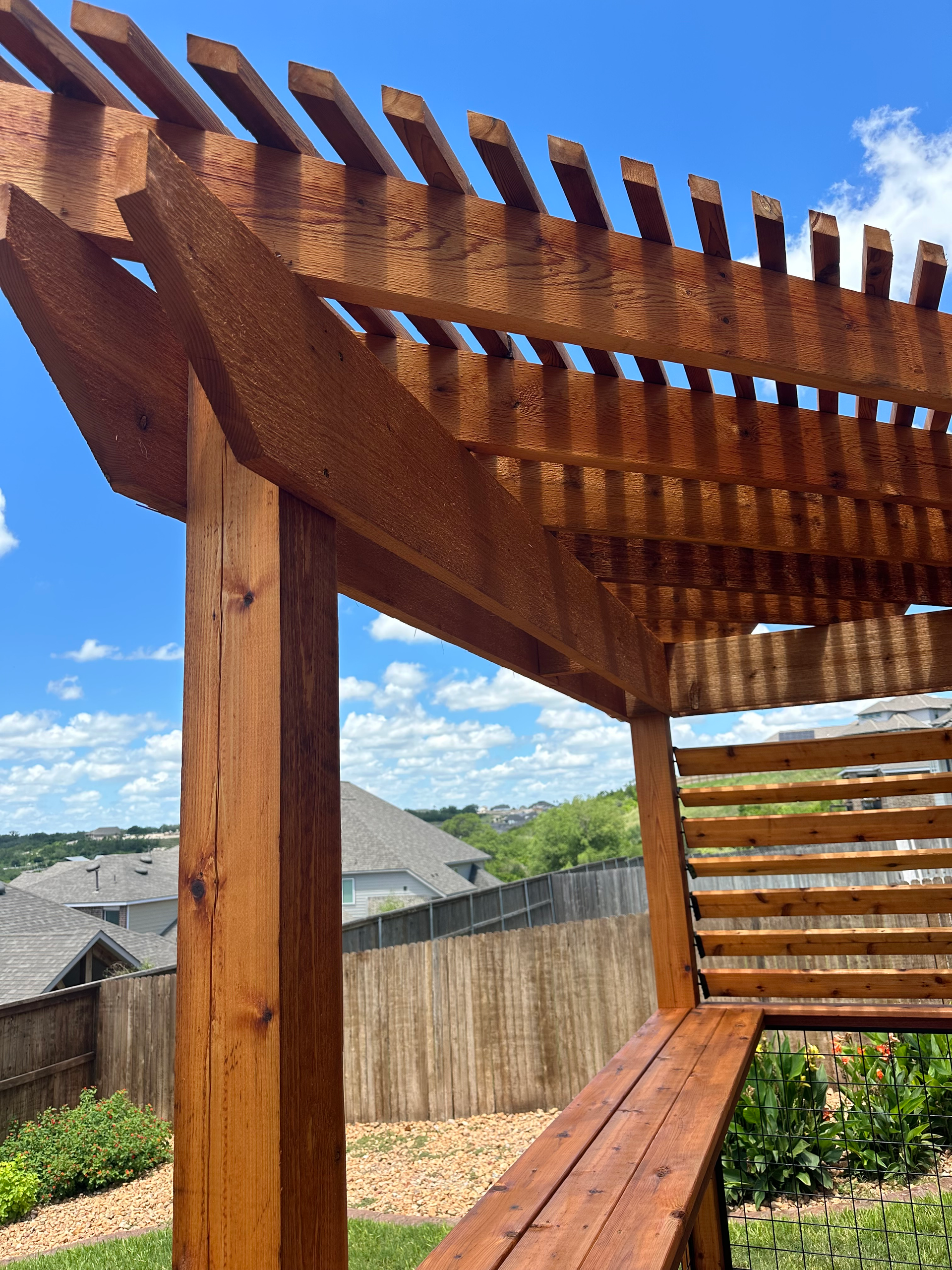 A wooden pergola with a bench underneath it