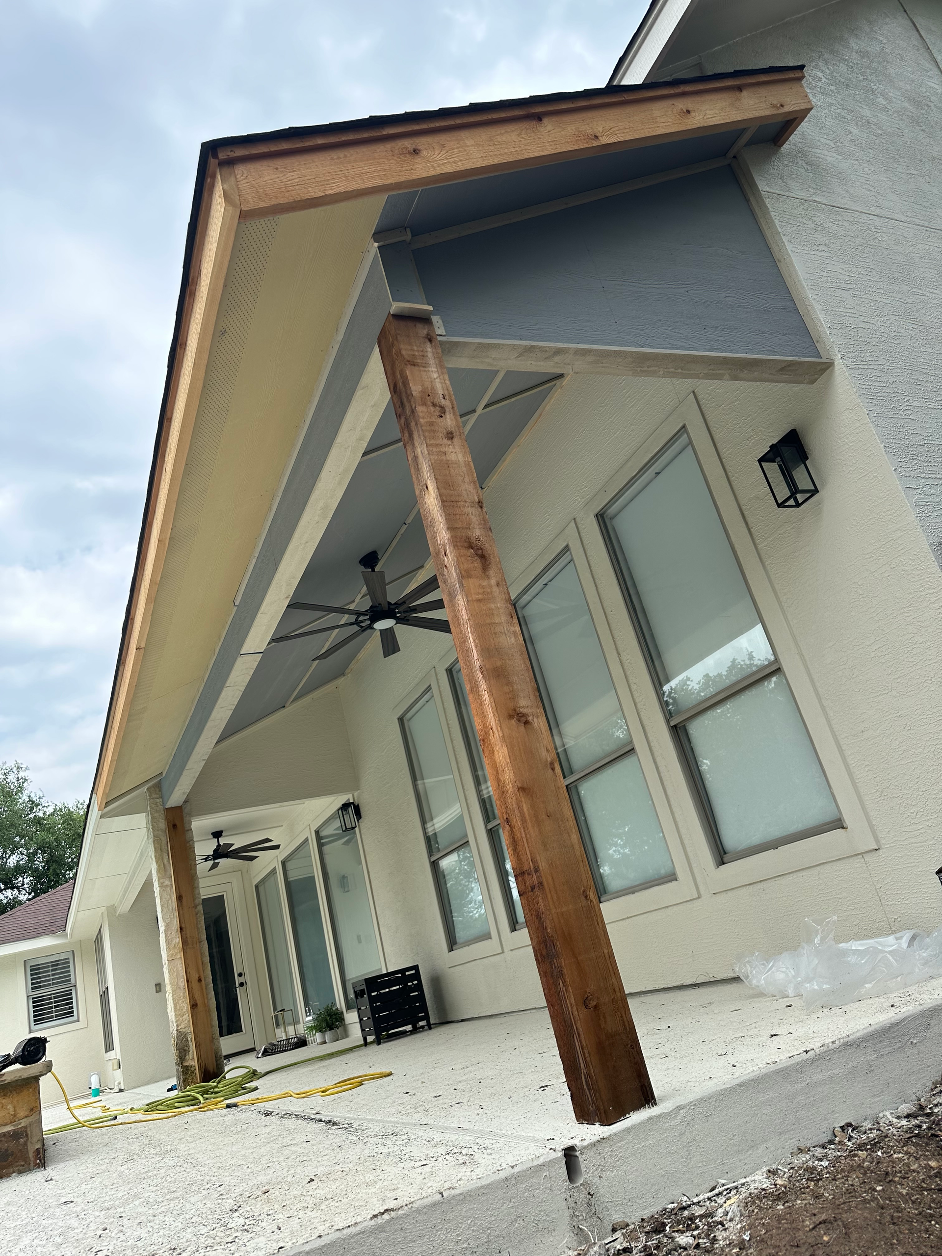 A white house with a wooden porch and a ceiling fan.