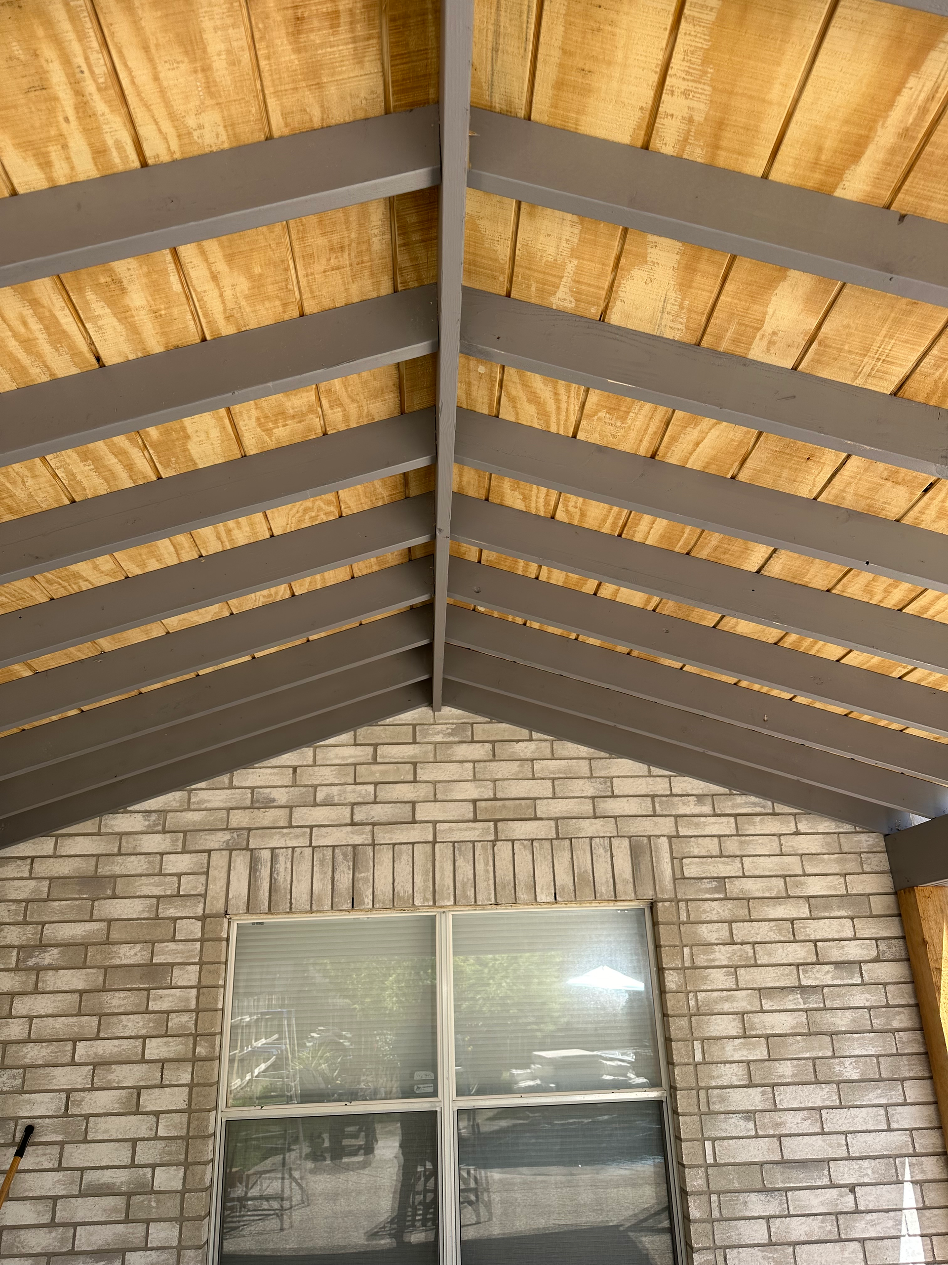 A brick wall with a wooden ceiling and a window