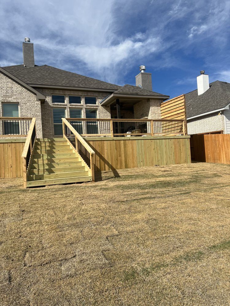 A house with a wooden deck and stairs in front of it.