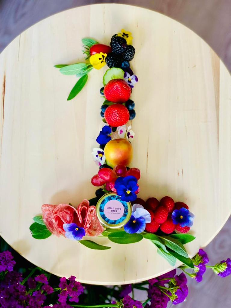 Elegant baby shower grazing table with artisan cheeses and fresh fruit.