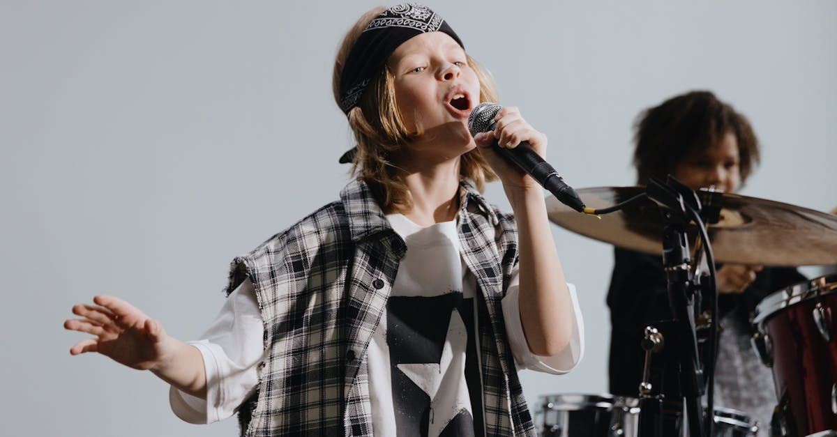 A little girl is holding a microphone in front of a sign that says the singing place Aboy singing in class with a group of adults by a piano