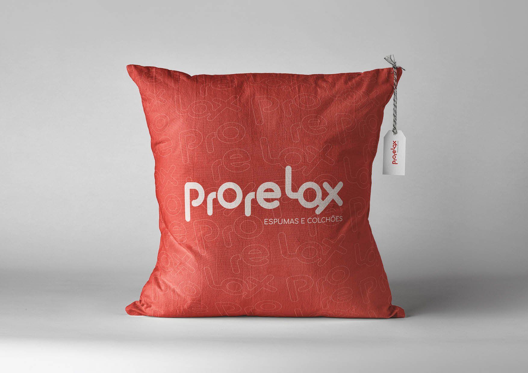 Almofada Prorelax vermelha com logotipo branco e etiqueta pendurada em um fundo neutro.