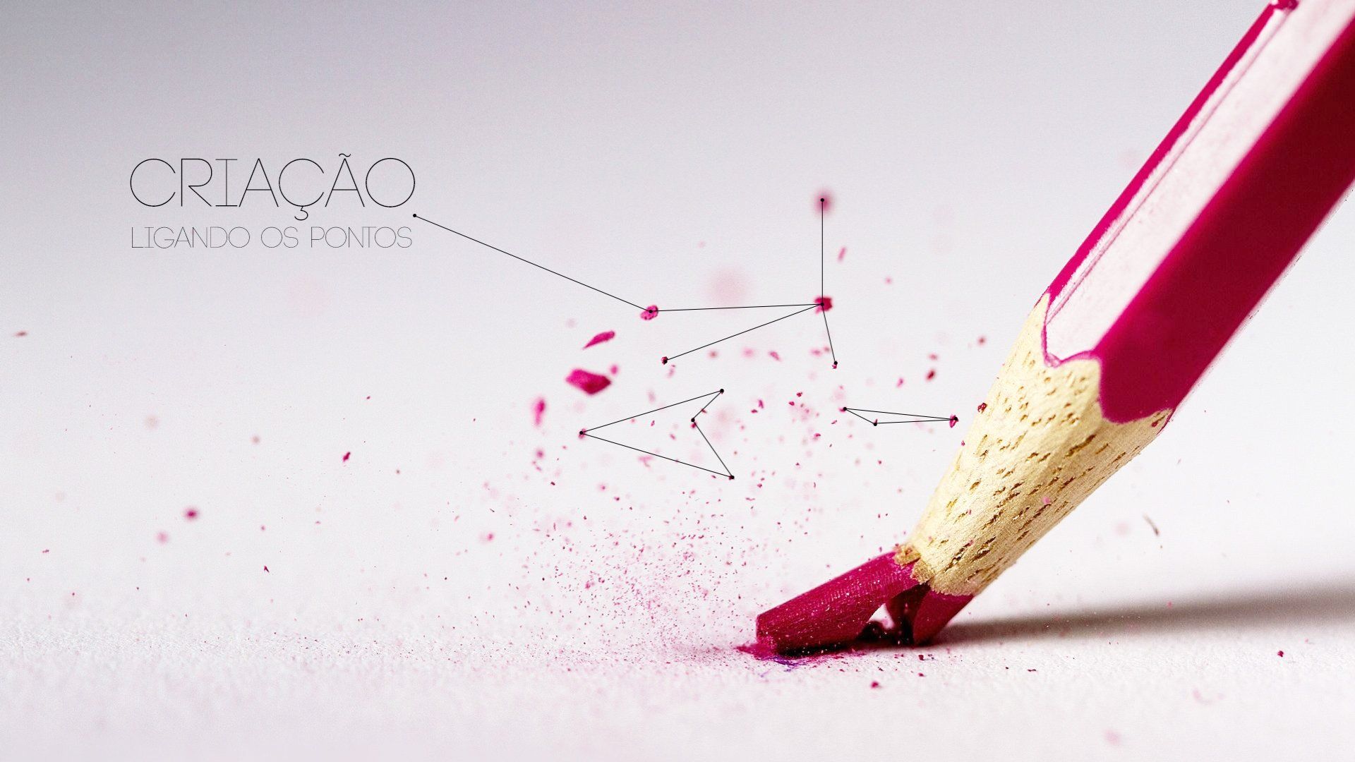 Um close de um lápis rosa quebrado em papel branco, com aparas espalhadas e o texto