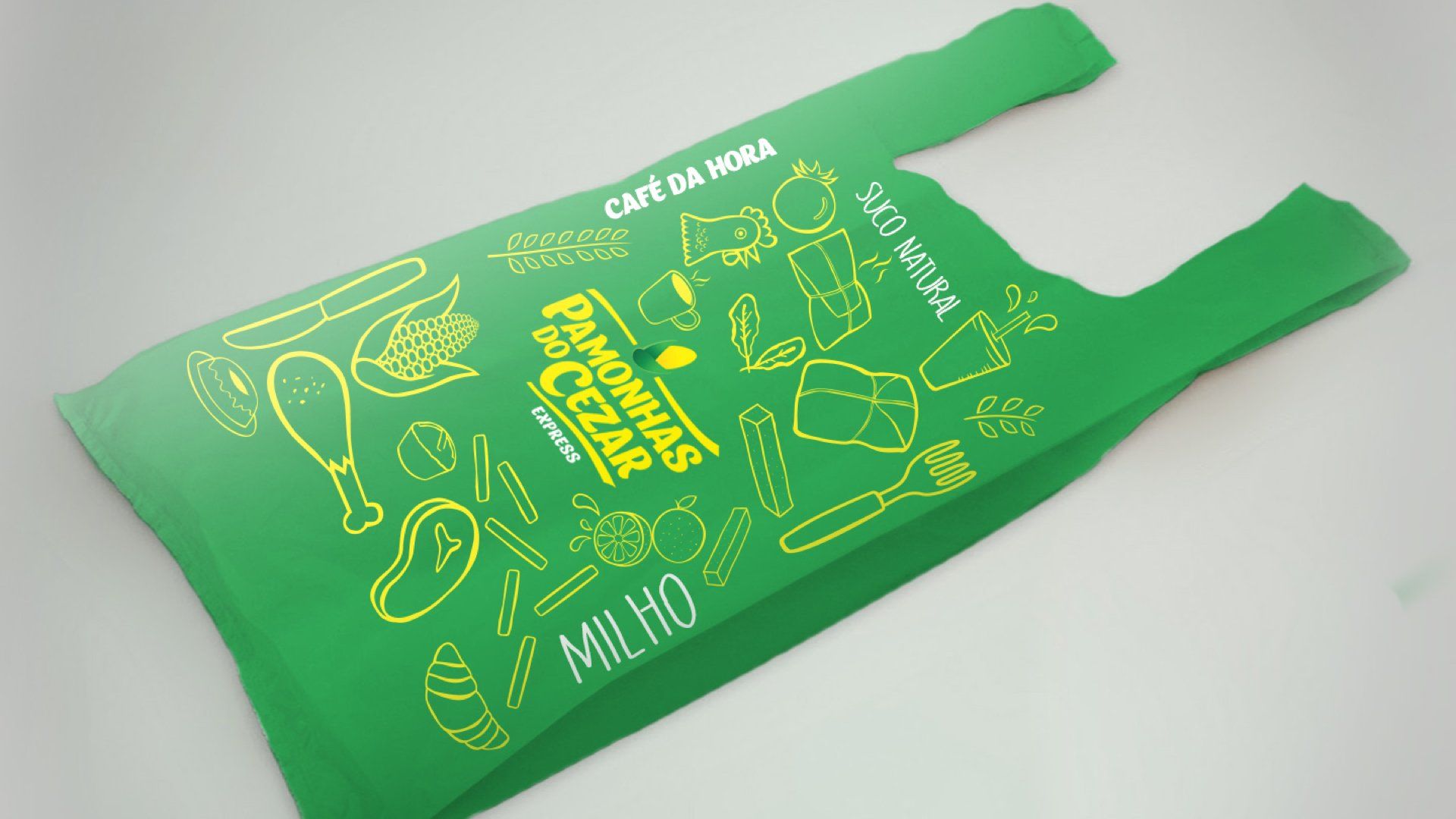 Sacola de compras verde com logotipo e ilustrações de comida, provavelmente para um café. Apresenta as palavras