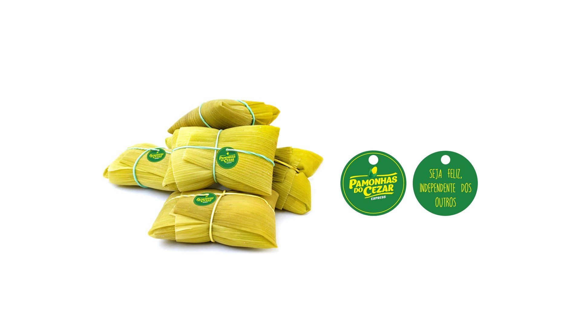 Pilha de tamales enrolados em palha de milho com duas etiquetas circulares verdes.