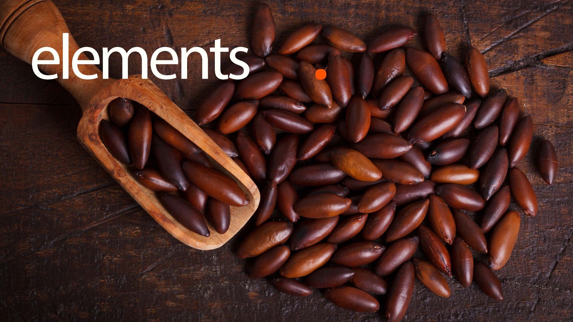 Colher de madeira cheia de sementes marrons e alongadas caindo sobre uma superfície de madeira escura, com o texto