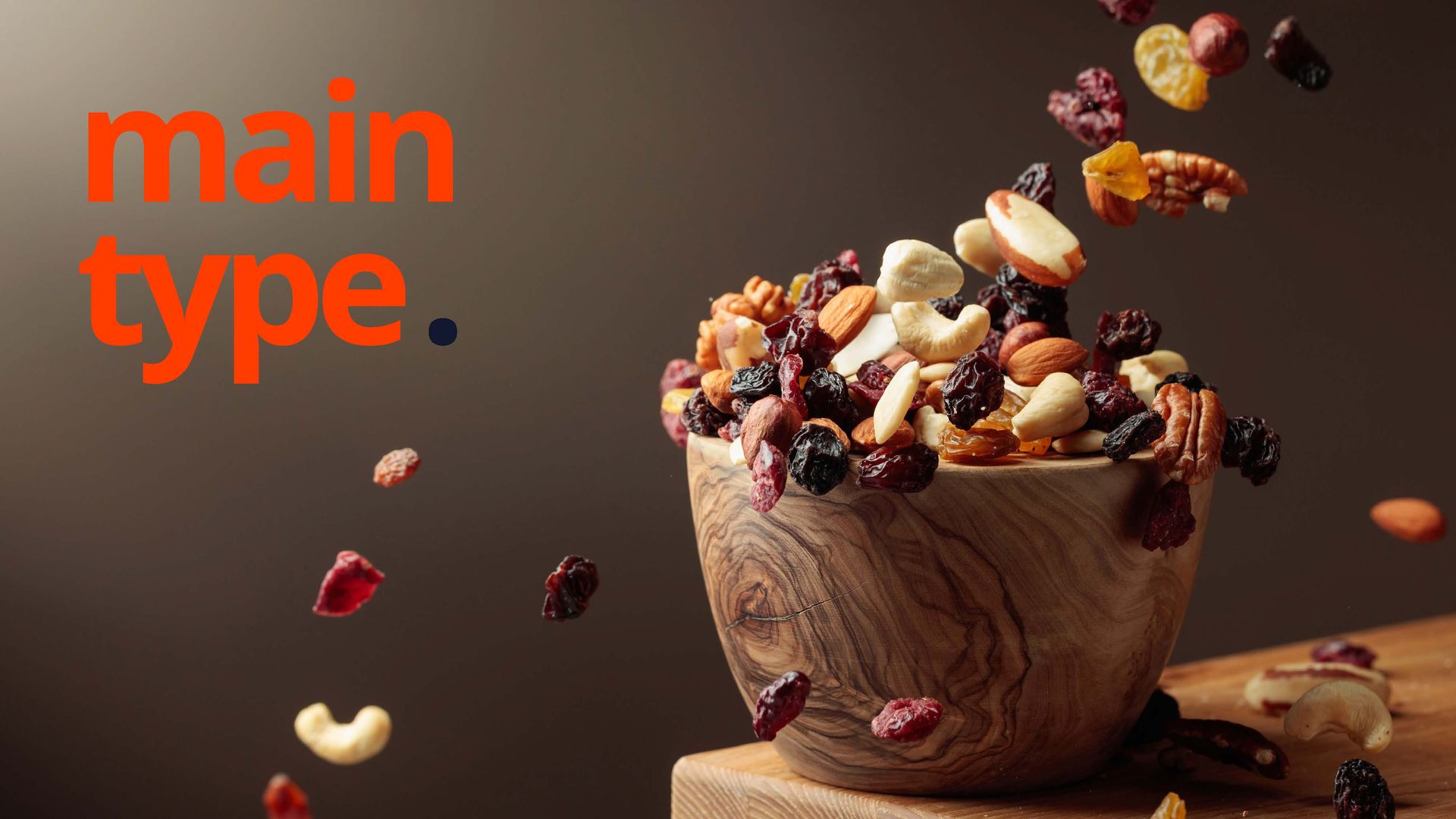 Tigela de nozes mistas com algumas nozes caindo; texto laranja