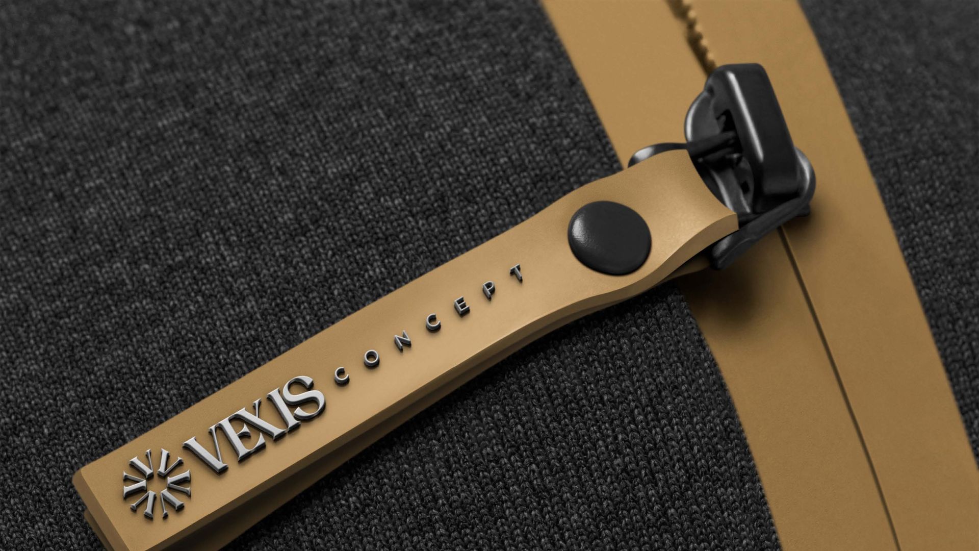 Close-up de um tecido cinza escuro com um zíper e uma aba de puxar bege, gravados com