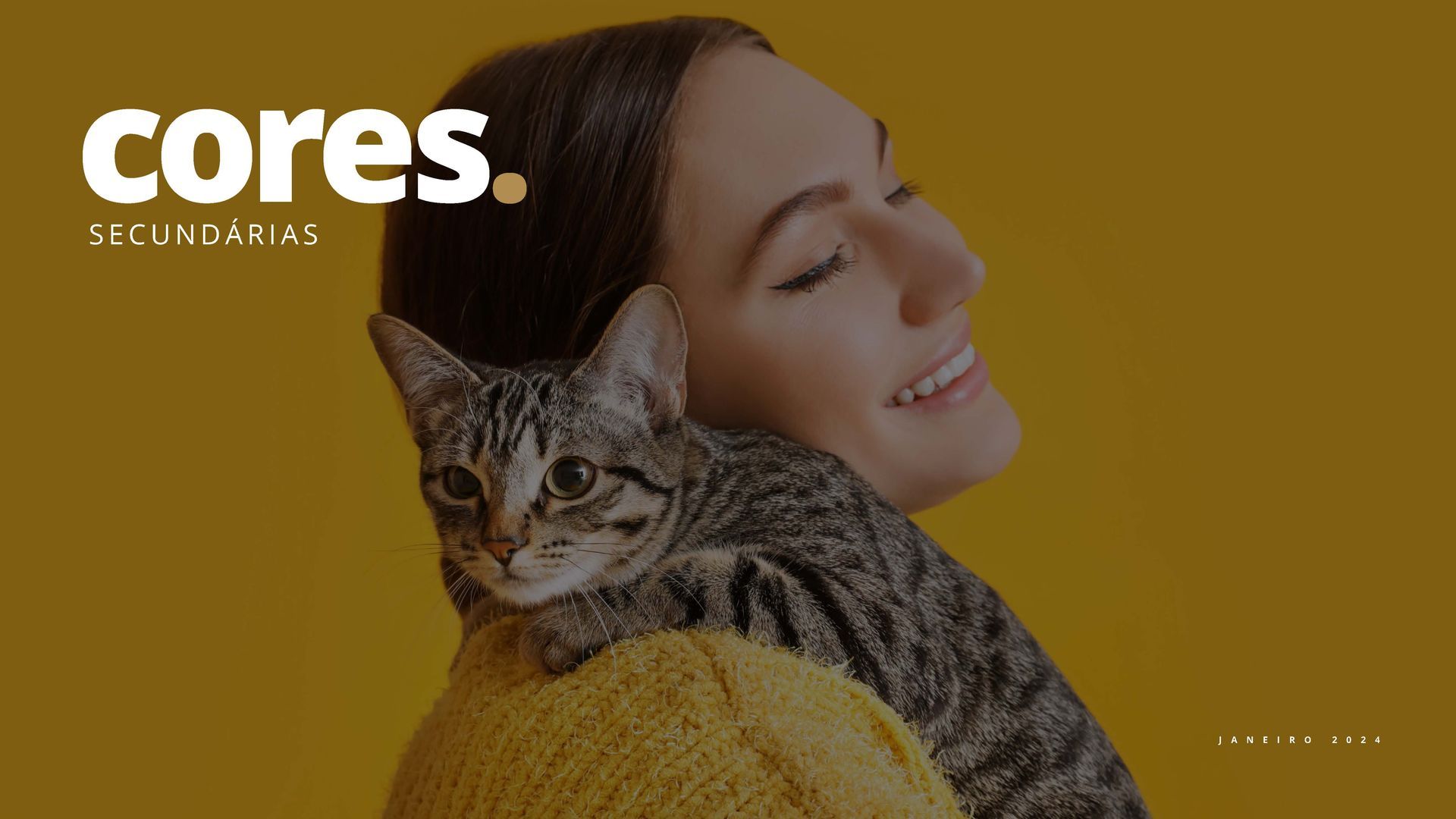 Uma mulher está segurando um gato no ombro.