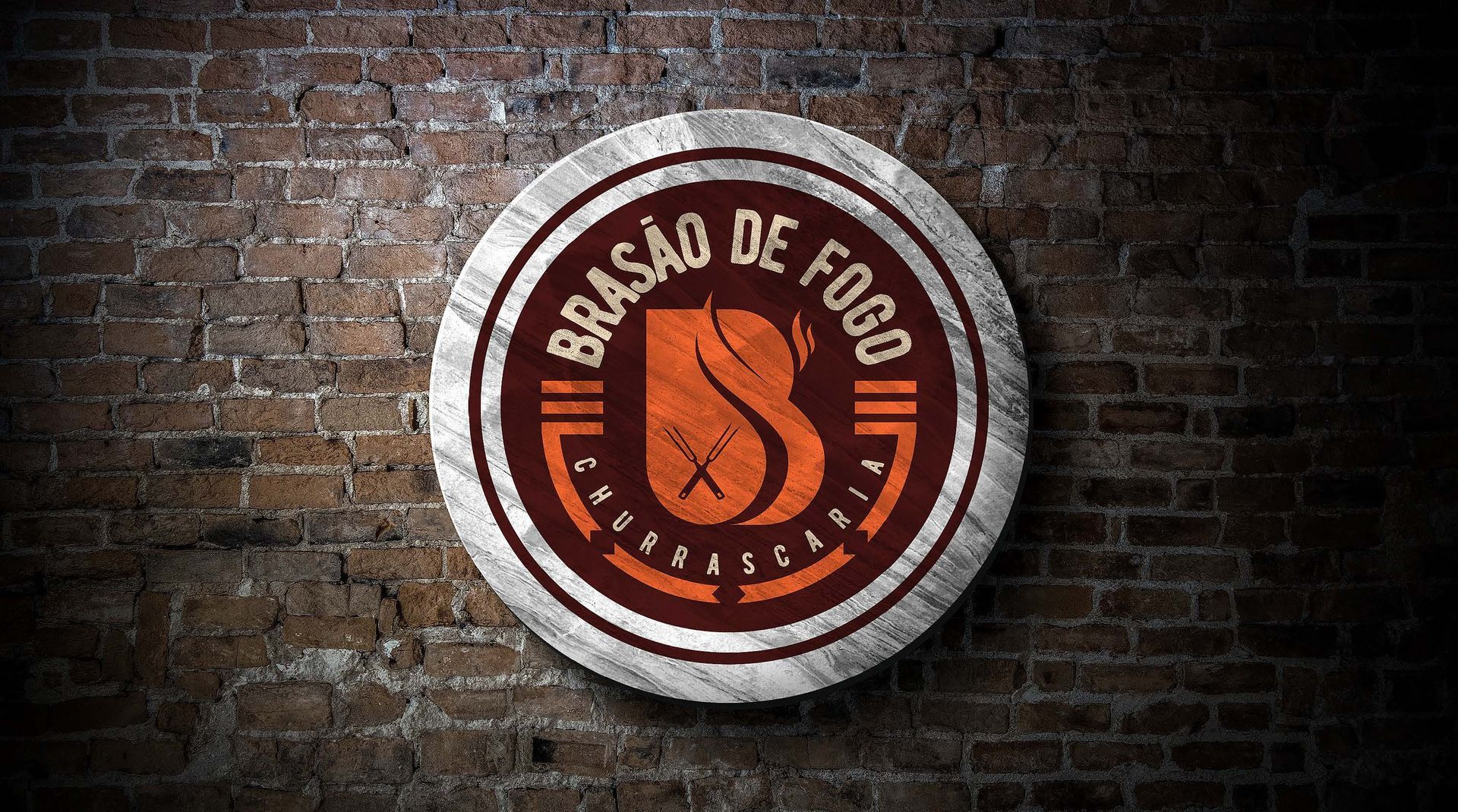 Logotipo da Brasão de Fogo sobre um fundo de parede de tijolos. O logotipo é uma placa circular de madeira com texto e design em laranja e marrom.
