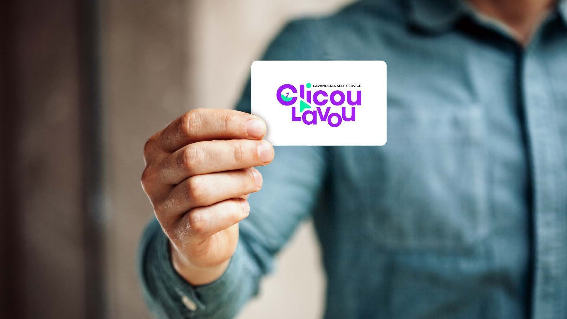 Pessoa segurando um cartão de visita com um logotipo colorido que diz