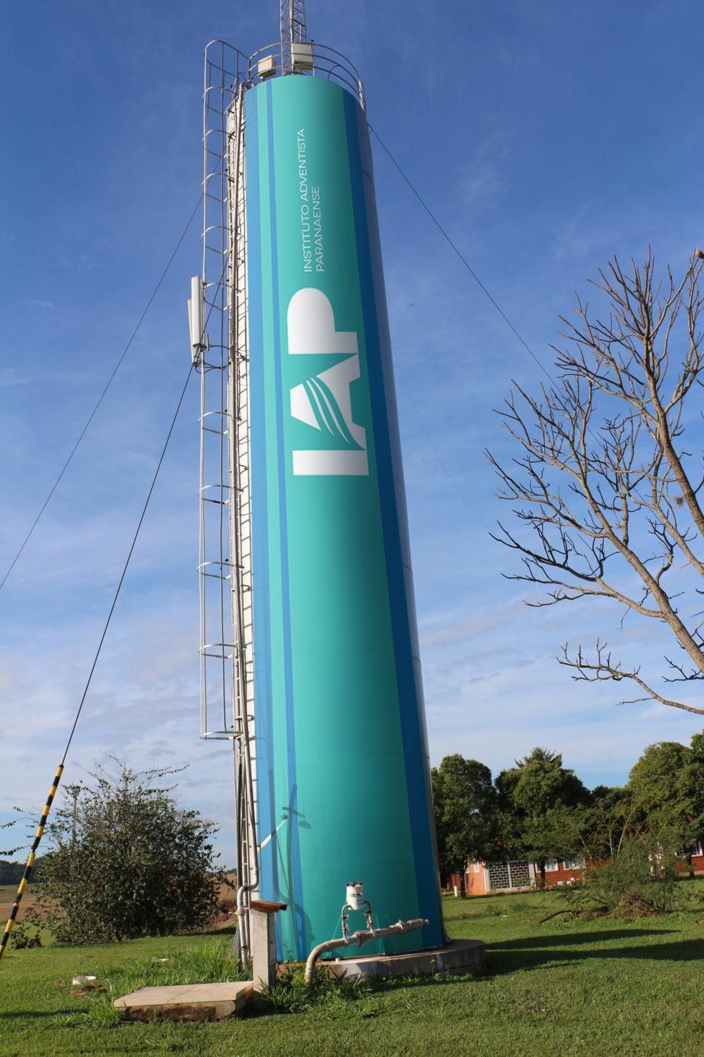 Alta torre de água azul-petróleo com as letras