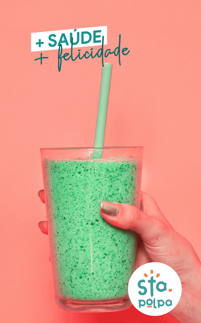 Uma mão segurando um smoothie verde em um copo com canudo, sobre um fundo rosa. O texto diz 