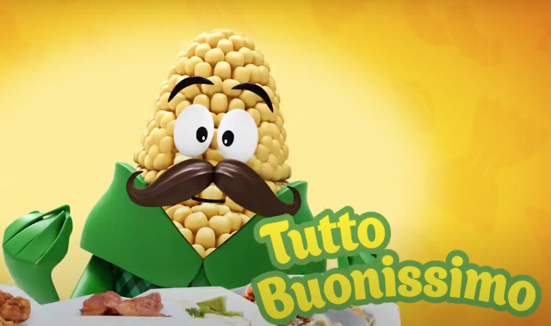 Um personagem de desenho animado de milho com bigode e roupa de chef, ao lado do texto