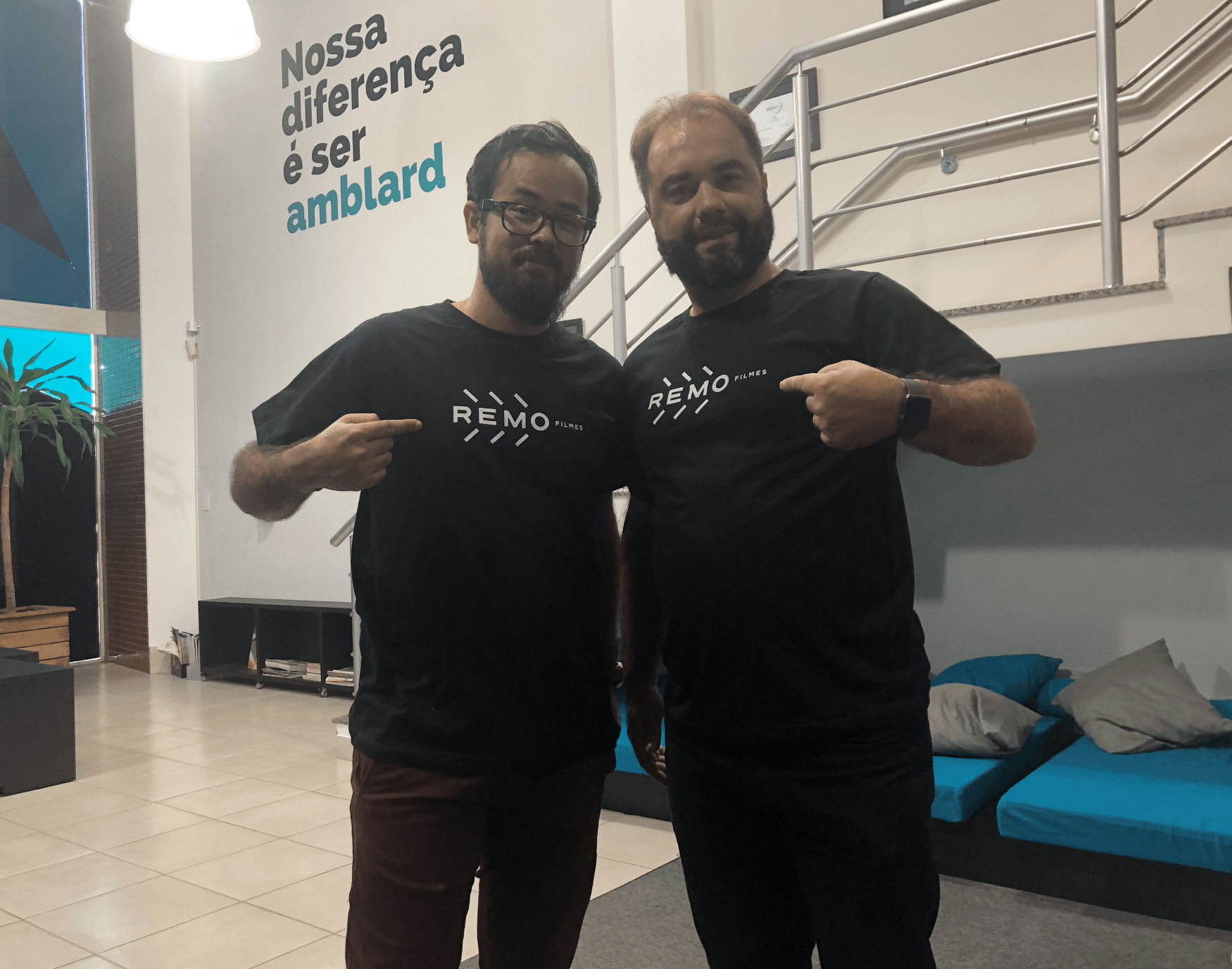 Dois homens vestindo camisetas pretas iguais com a palavra
