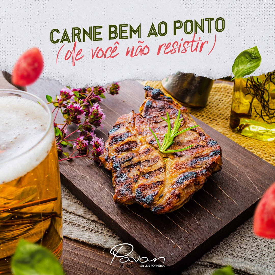 Um bife está sobre uma tábua de madeira ao lado de um copo de cerveja.