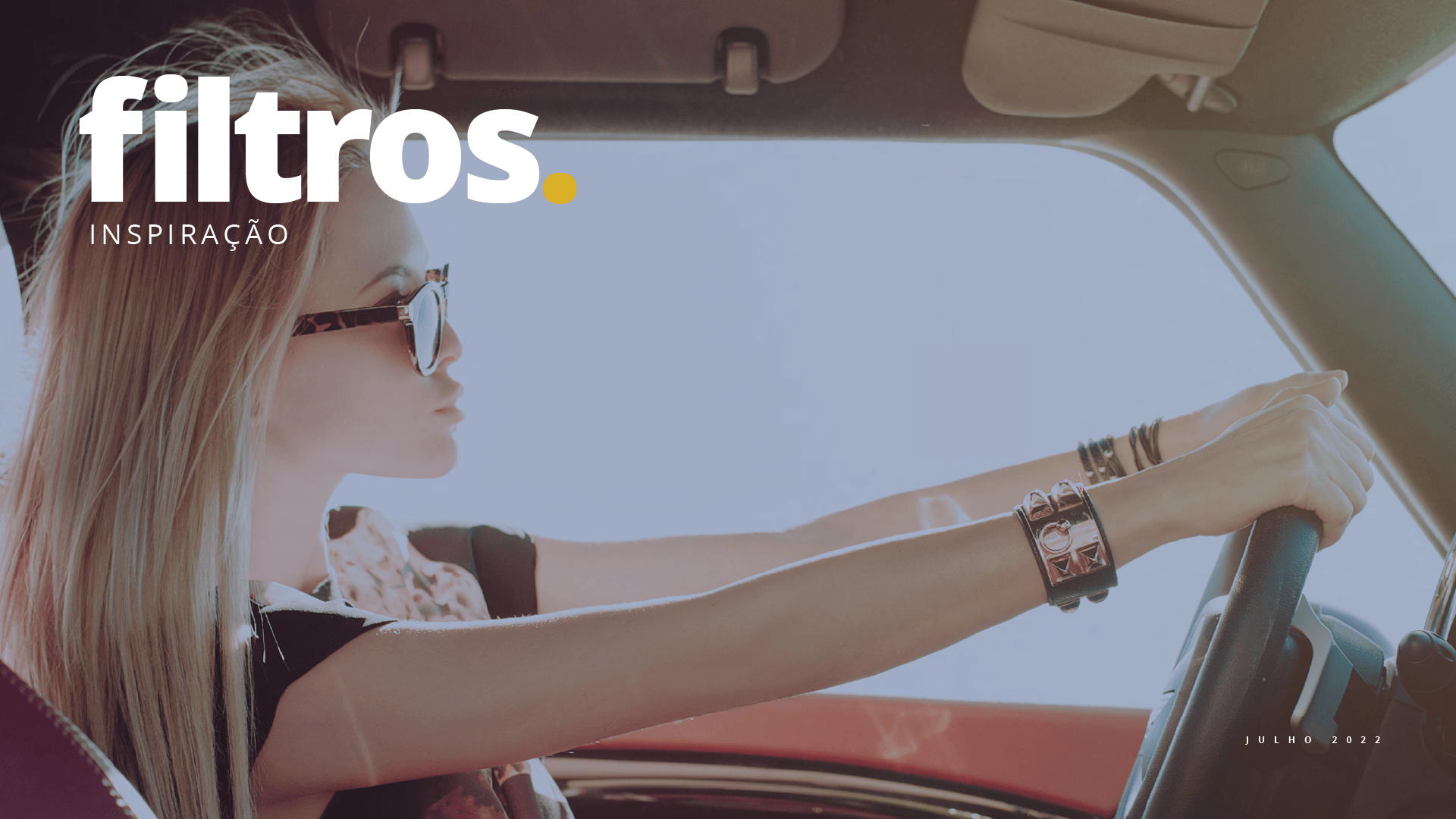 Uma mulher usando óculos de sol está dirigindo um carro.