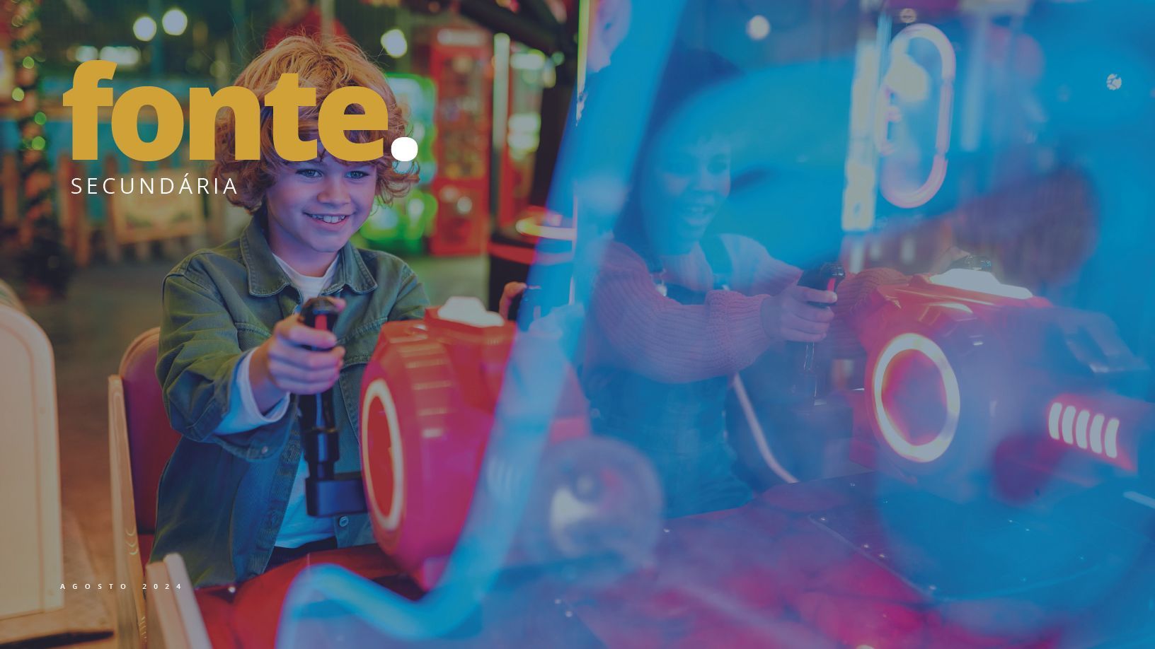 Um menino sorri enquanto joga videogame em um parque de diversões. Ele segura um controle e uma luz azul brilhante brilha.