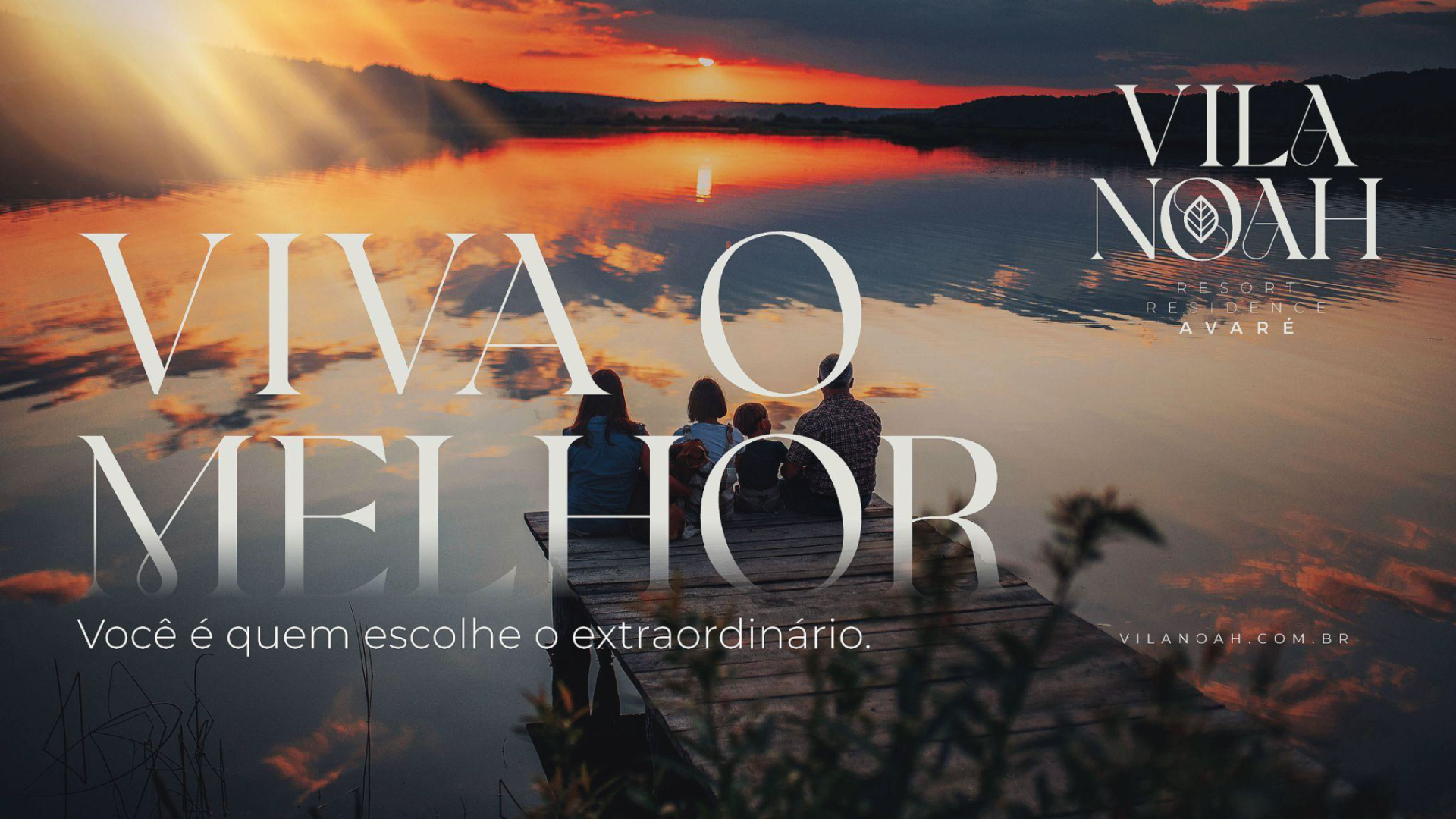 Um grupo de pessoas está sentado em um penhasco com vista para um lago.