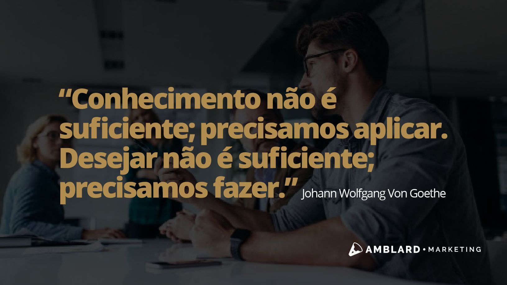 Um homem está sentado à mesa com uma citação em uma língua estrangeira.