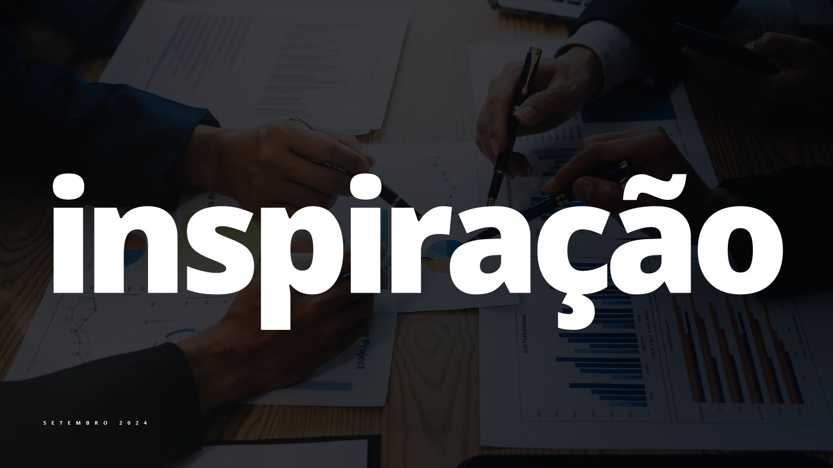 Um grupo de pessoas está sentado em uma mesa com a palavra inspiração em letras brancas