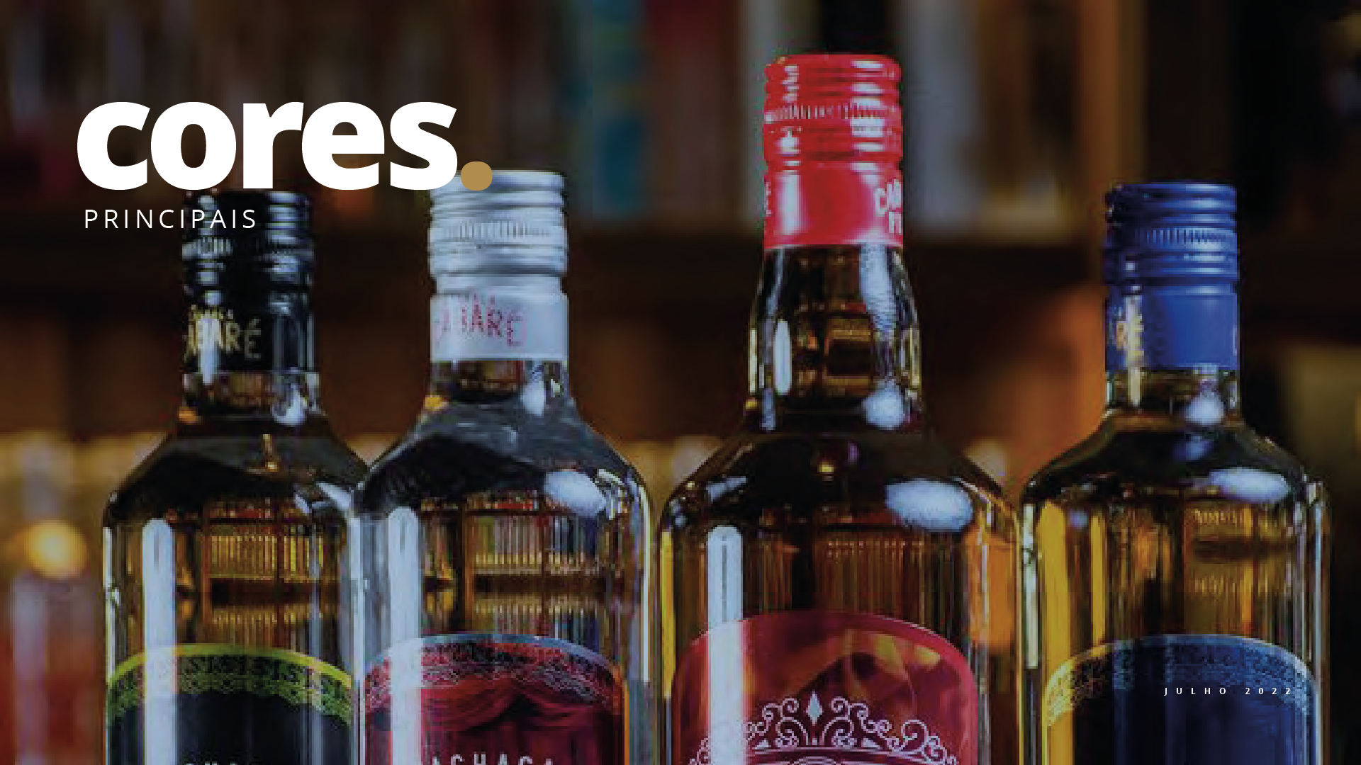 Quatro garrafas de álcool estão alinhadas uma ao lado da outra sobre uma mesa.