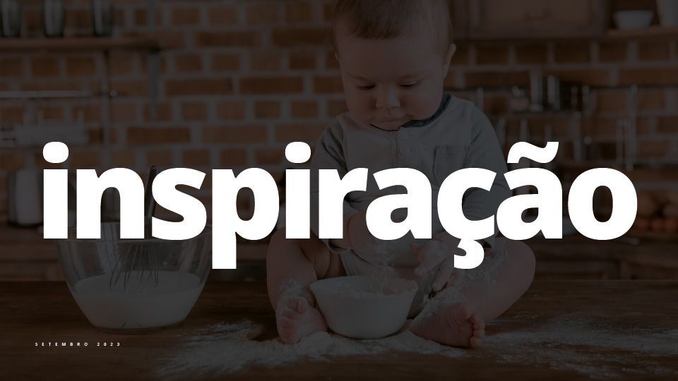Um bebê sentado em uma mesa brincando com farinha perto de uma tigela de vidro; a palavra