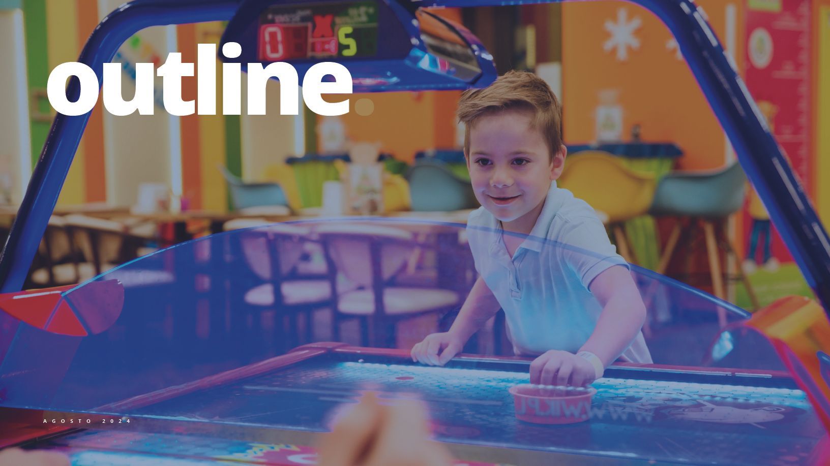 Menino jogando hóquei de ar em um fliperama colorido. Ele tem uma expressão feliz e está concentrado no jogo.