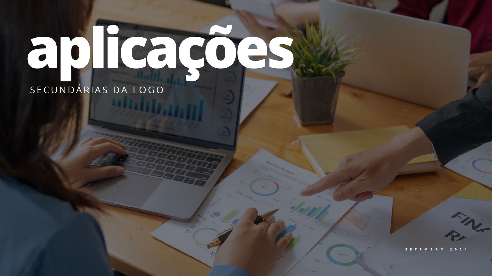 Uma mulher está sentada à mesa usando um laptop.