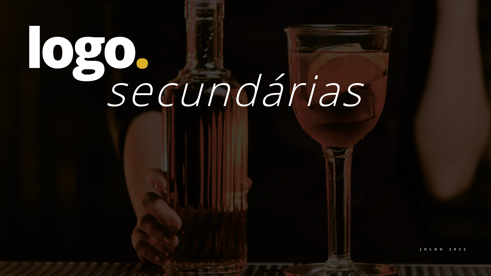 Uma pessoa está segurando uma garrafa de álcool e uma taça de vinho.