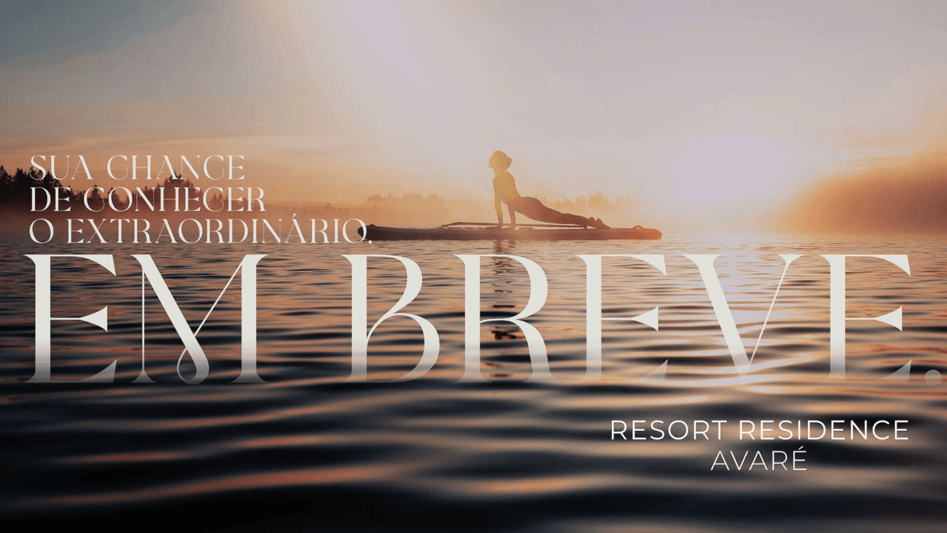 Uma pessoa está em pé em uma prancha de remo na água.