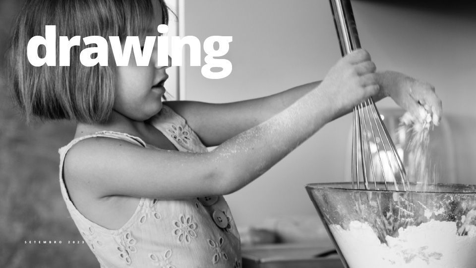 Menina misturando ingredientes em uma tigela com um batedor, polvilhando farinha nos braços.