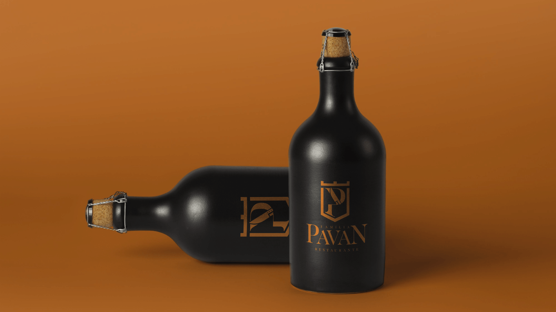 Duas garrafas de vinho pretas com letras douradas sobre um fundo laranja. Uma garrafa está em pé, a outra deitada.