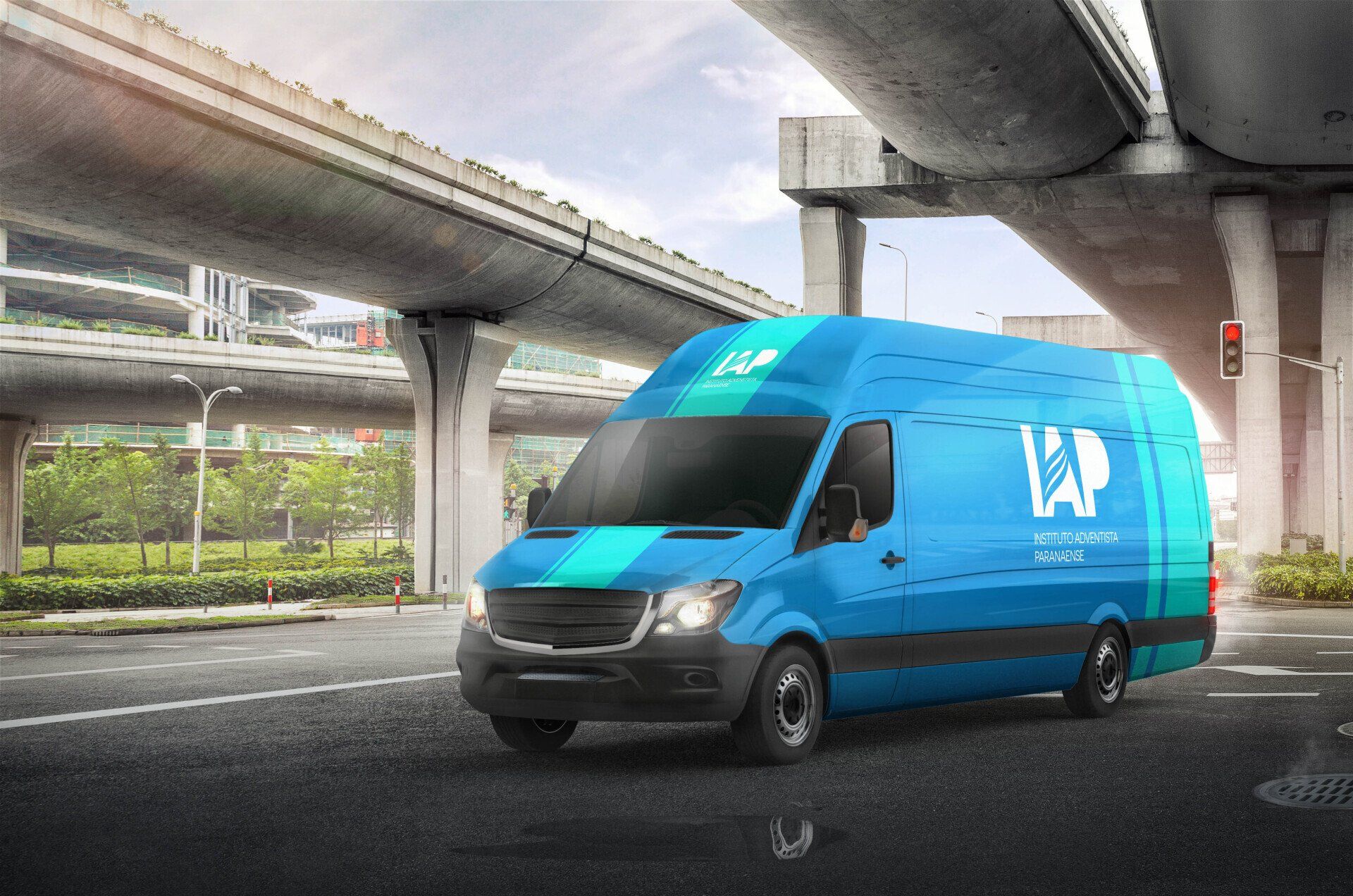 Van de entrega azul com logotipo da empresa circulando em uma rua da cidade, sob um viaduto.