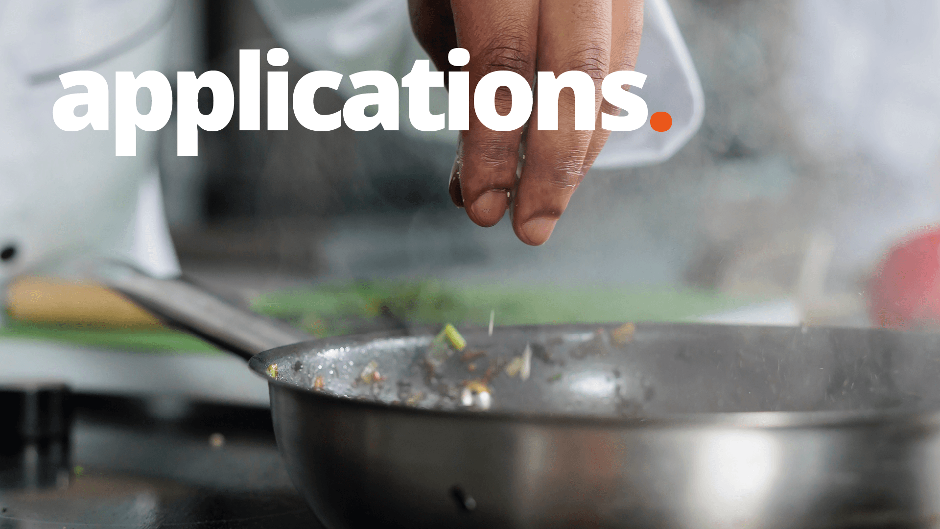 Uma pessoa está espalhando sal em uma frigideira.